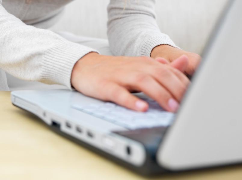 Dłonie na białym laptopie